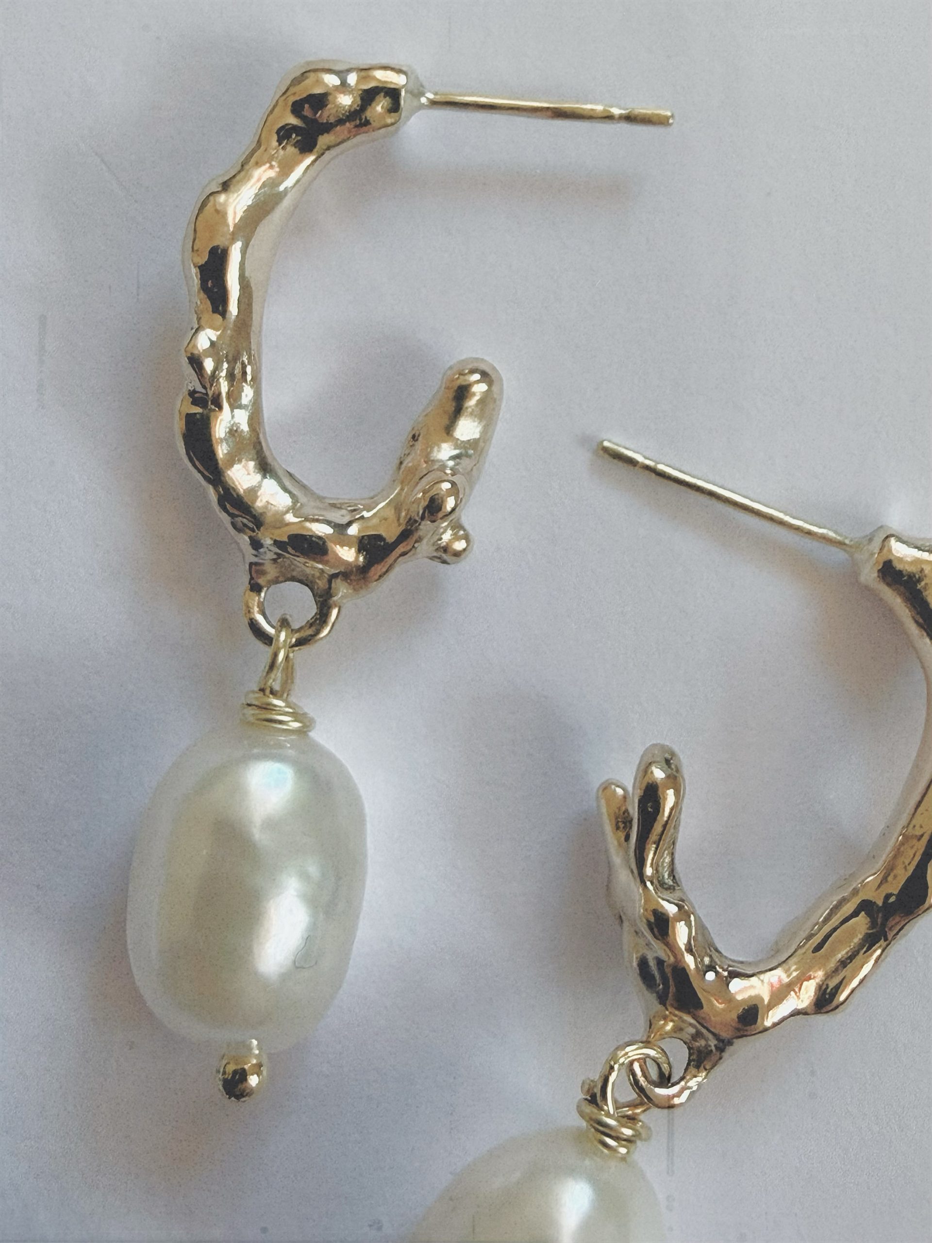 closeup organic shape hoop earrings with freshwater pearls