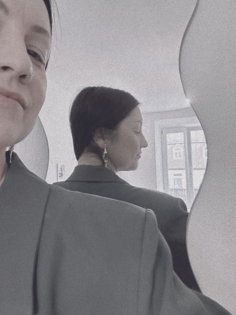 Portrait of jewellery designer Brigitta Barczi wearing sculptural earrings